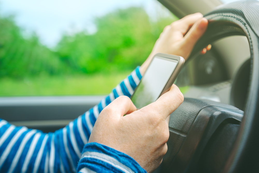 Close up of woman texting on phone while driving