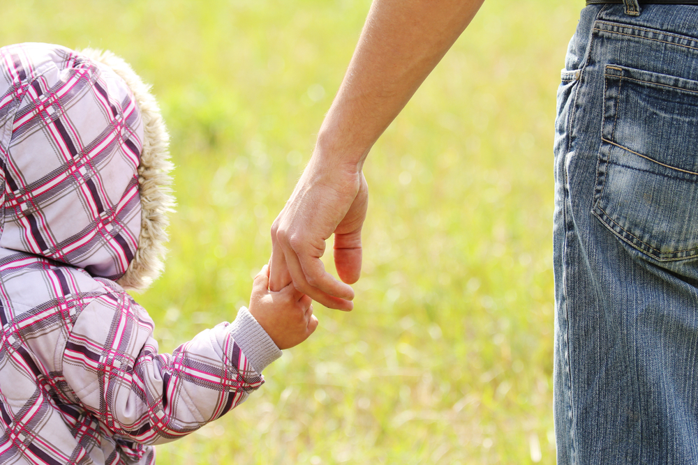 Parent holding hand of child in warm coat