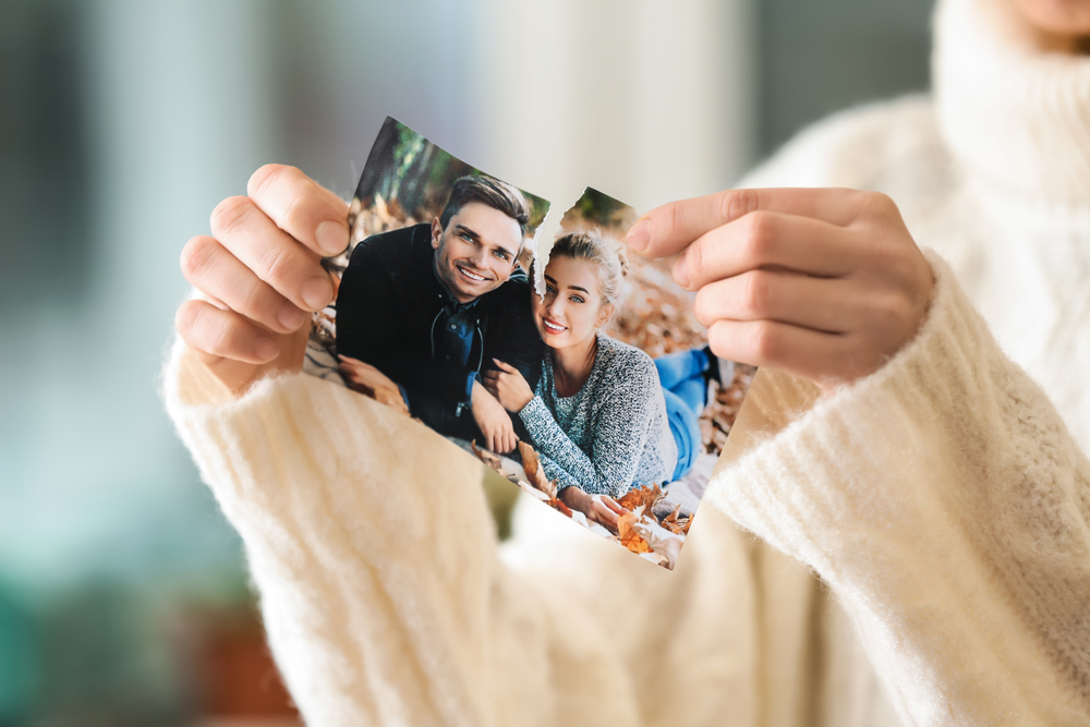 Woman ripping photo of couple