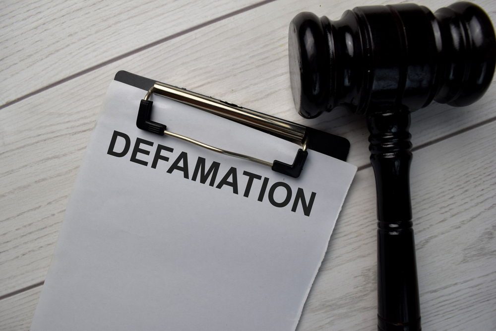 Defamation written on clipboard next to black gavel