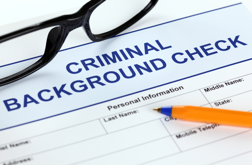 Application for criminal background check with glasses and pen