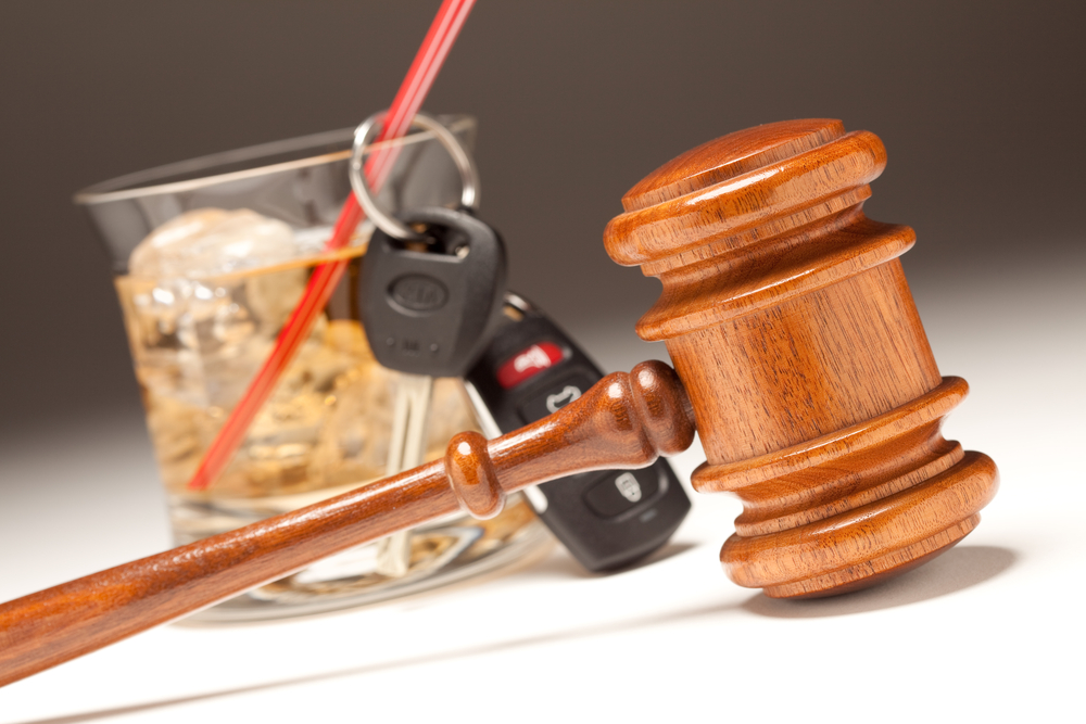 Glass of alcohol, car keys, and judge's gavel