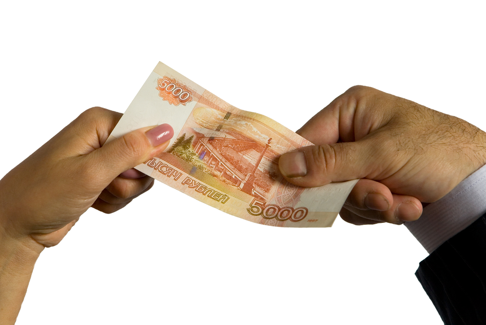 Man and woman's hands holding Russian bill