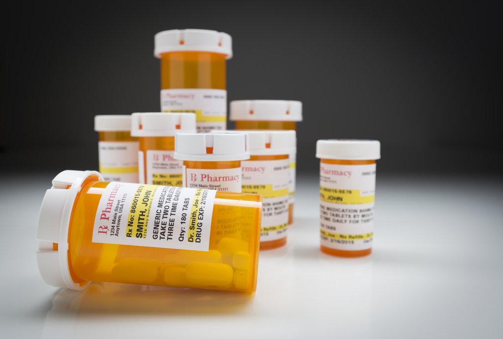 Collection of prescription medicine bottles on gray backdrop