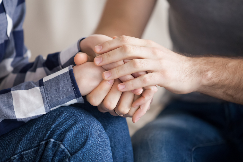 Close up of couple holding hands and making up