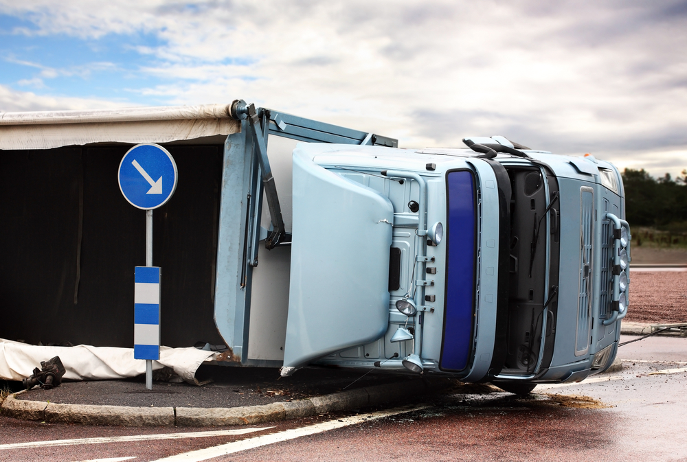 Overturned semi-truck near road sign