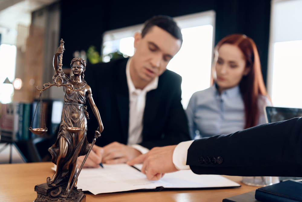 Man and woman signing documents at divorce attorney's office