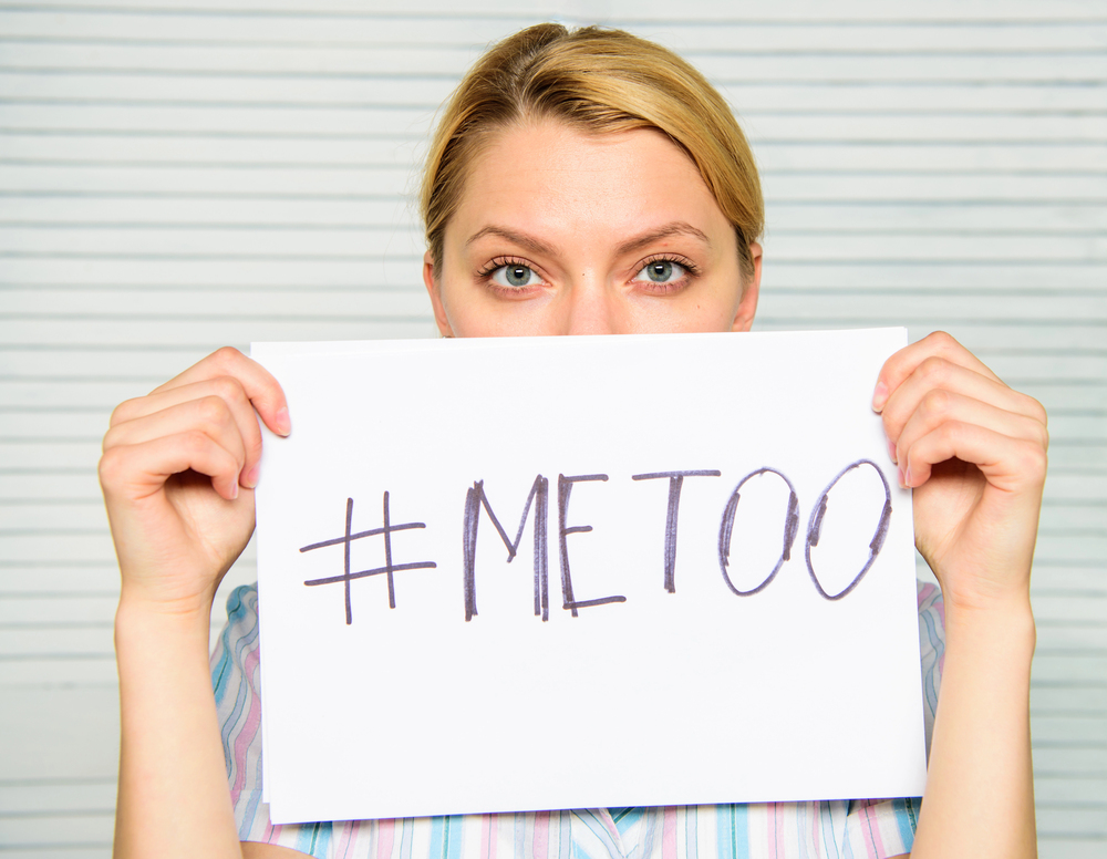 Woman holding up sign with #MeToo written on it