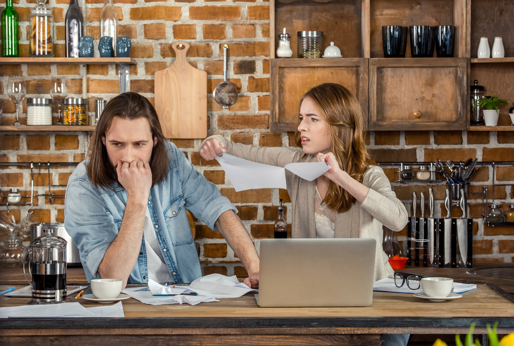 Woman ripping up pairs next to upset man