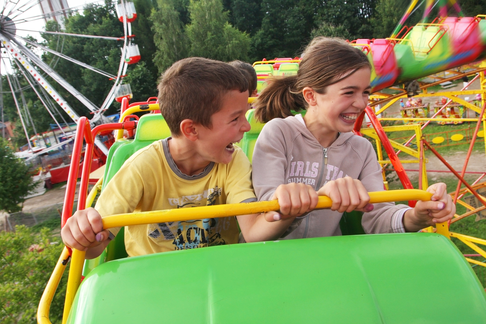 Children riding rollercoaster at theme park