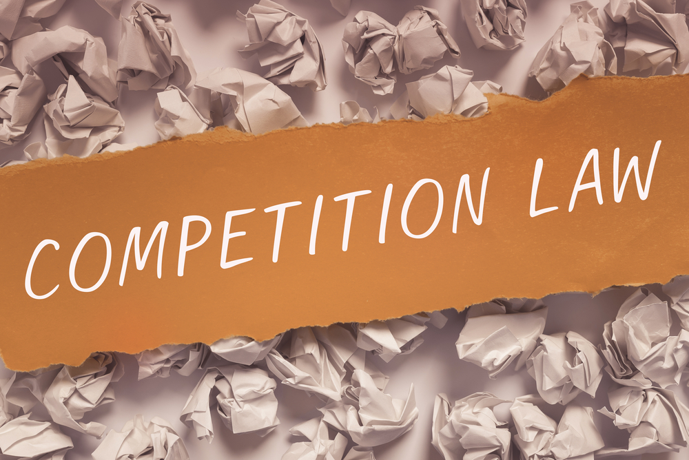 Competition Law written on strip of paper atop crumpled papers