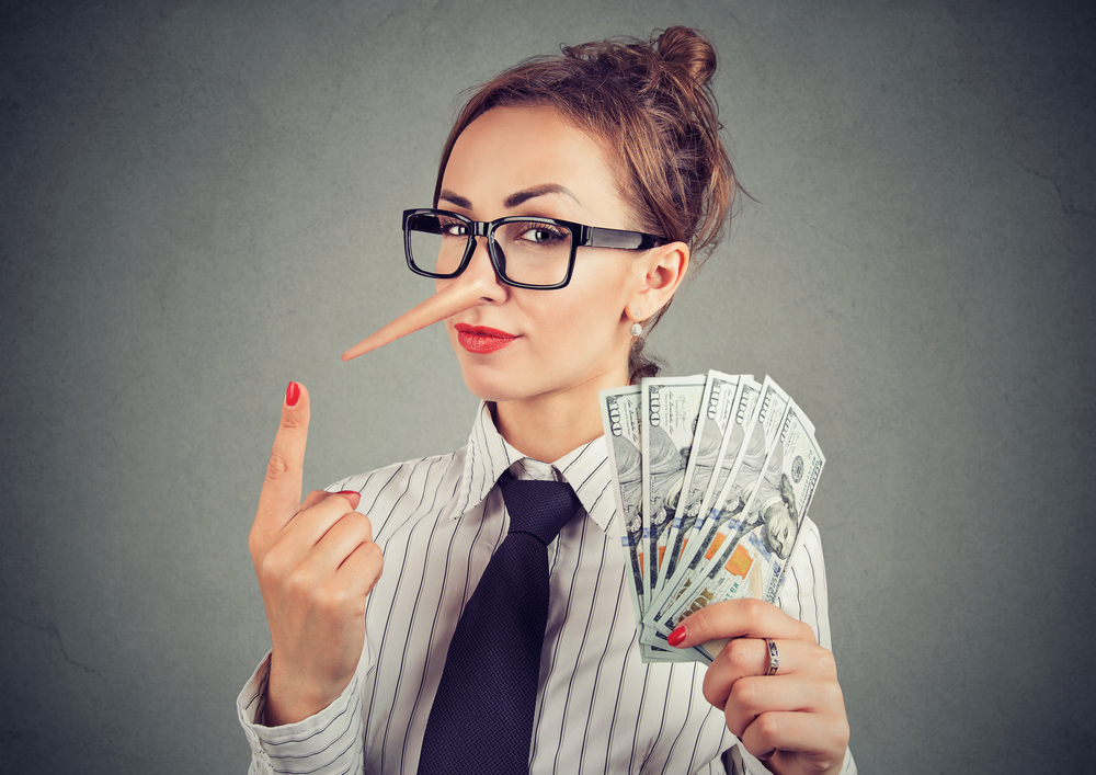 Businesswoman with handful of money and long nose, implying lies