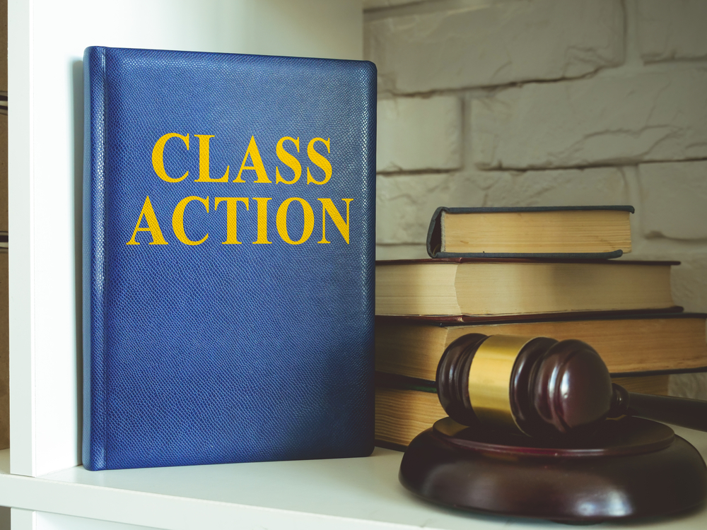 Class action law book on shelf next to judge's gavel