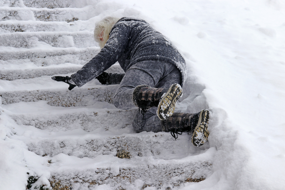 Elderly woman slipping and falling on icy stairs