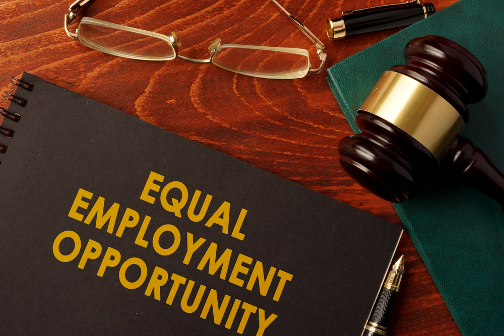 Equal employment opportunity notebook on desk with gavel and glasses