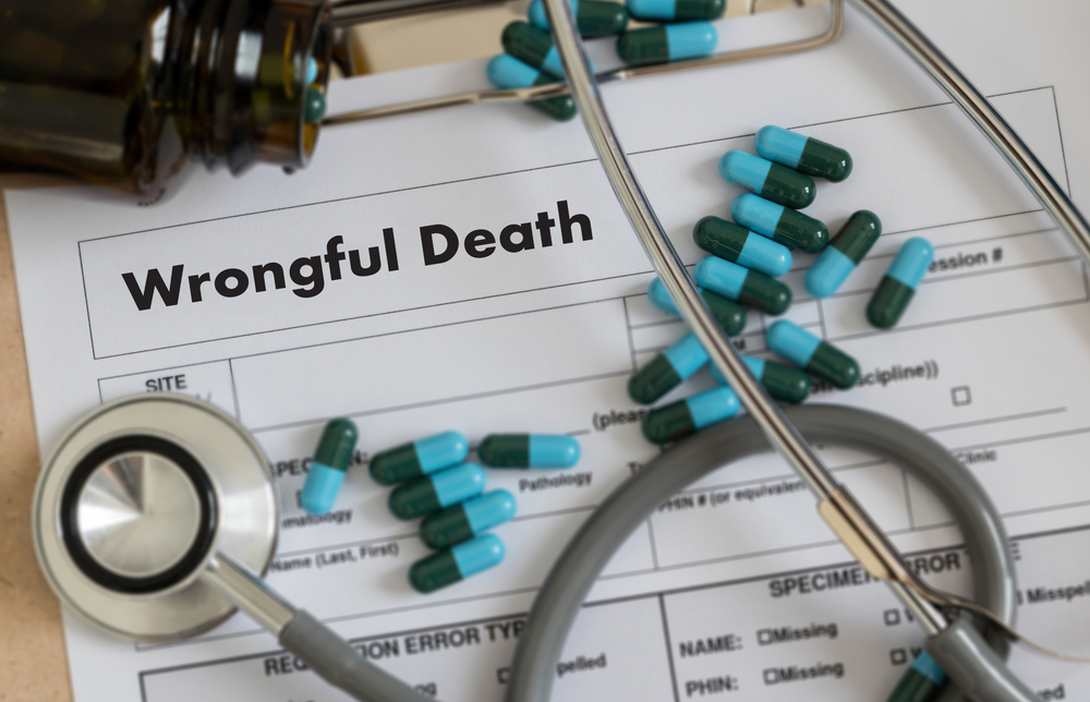 Stethoscope and pills atop wrongful death papers